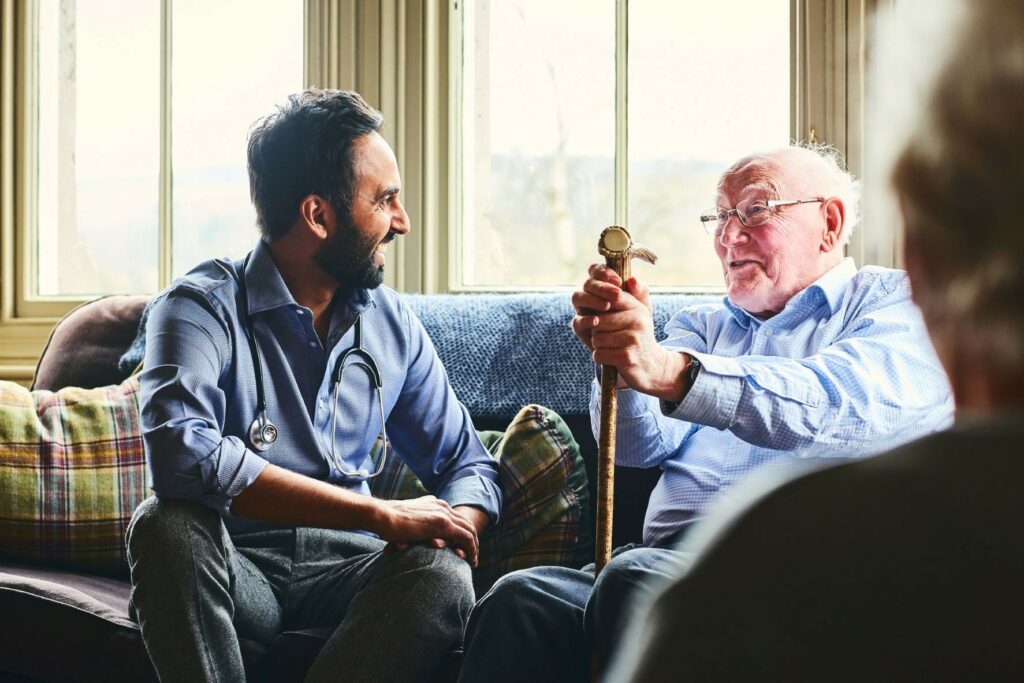 A family member laughs with a hospice patient in hospice care.