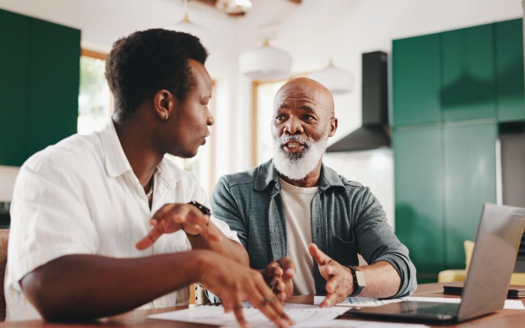 An African-American adult male talks to his senior father about advance care planning.