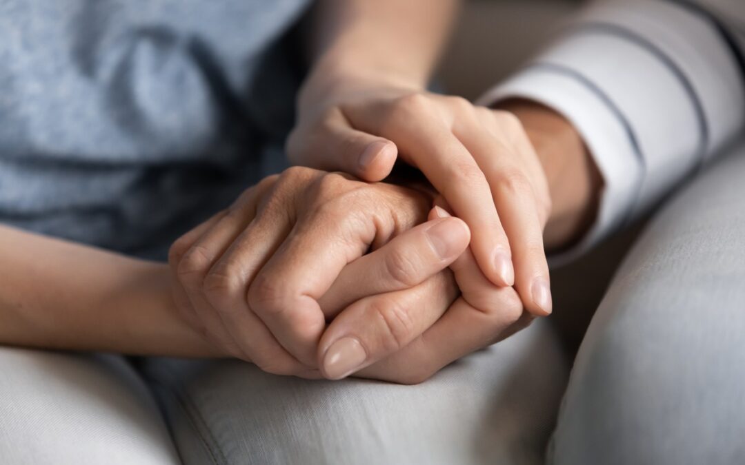 Holding hands offering emotional support in hospice care and grief.