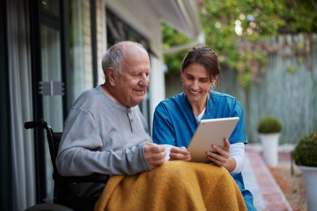 A man in a wheelchair receiving palliative care at home.