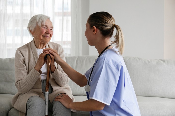 An elderly woman receiving palliative care from a skilled nurse.