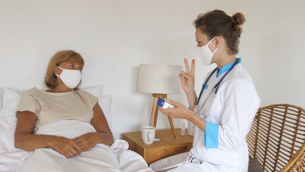 Home health care visit consultation between nurse and elderly patient at home